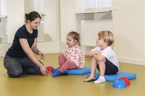 Kineziterapeutas atlieka masažą kūdikiui