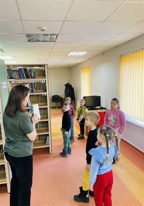 vaikų grupė džiaugiasi skaitydama savo pačių sukurtą knygą