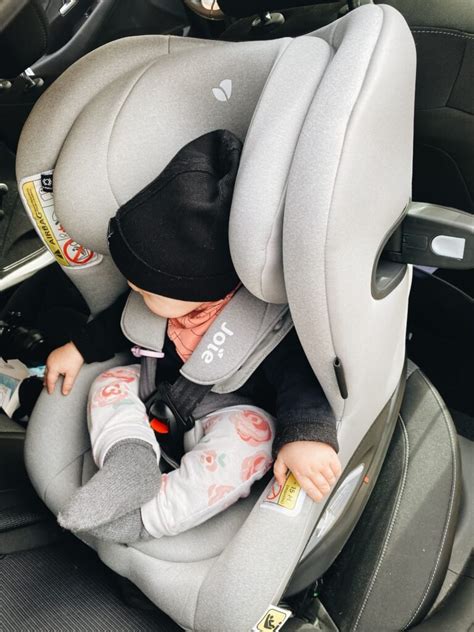 naujagimio automobilinė kėdutė vežama nugara į važiavimo kryptį