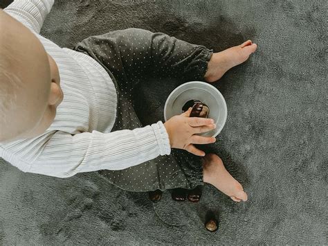 8 mėnesių kūdikis laiko smulkų daiktą pirštukais