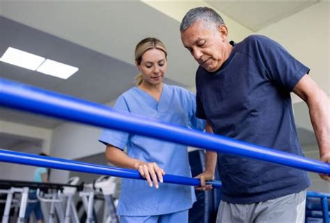 kineziterapeutas atlieka mankštą su kūdikiu