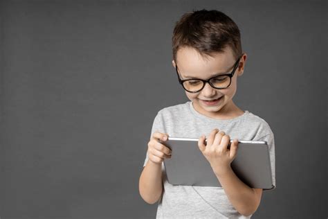 vaikas, sunkiai susikaupiantis prie knygų