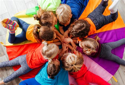 Nuotrauka, vaizduojanti vaikus, žaidžiančius lauke prie bendruomeninių vaikų globos namų