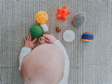 Kūdikis penkių mėnesių amžiaus, žaidžiantis su žaisliukais