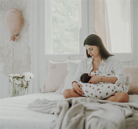 Mama žindo kūdikį su žindymo pagalve