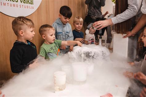 Nuotrauka, vaizduojanti vaikų žaidžiančius ir mokyklinius užsiėmimus