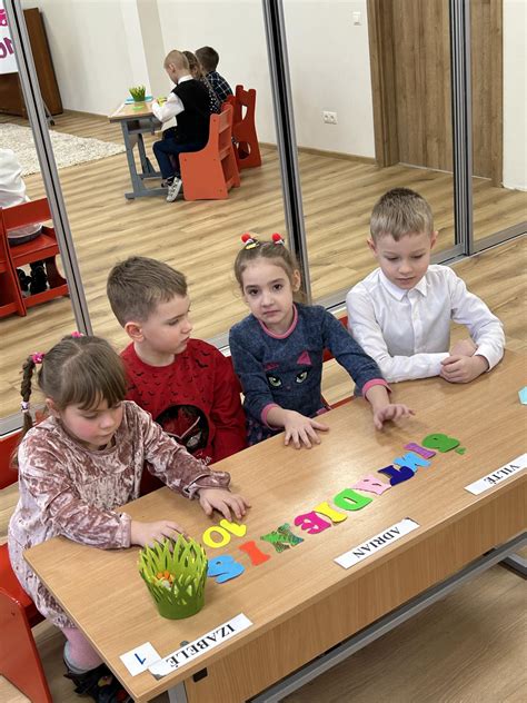 Vaikas, rašantis raidę priešmokyklinėje grupėje