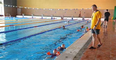 Vaikai baseine žaidžia ir mokosi plaukti