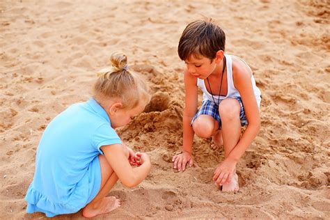 Vaikai, renkantys akmenukus paplūdimyje