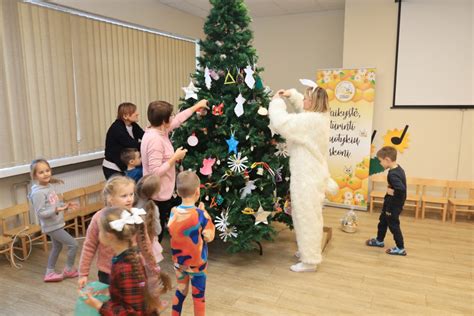 šeima kartu puošia kalėdinę eglutę