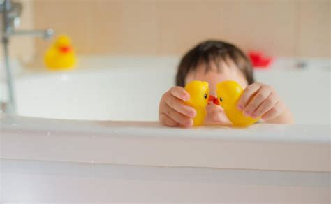 Vaikas maudosi vonioje su muilo putomis