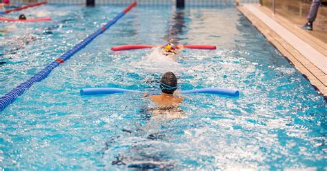 Vaikas mokosi plaukti baseine