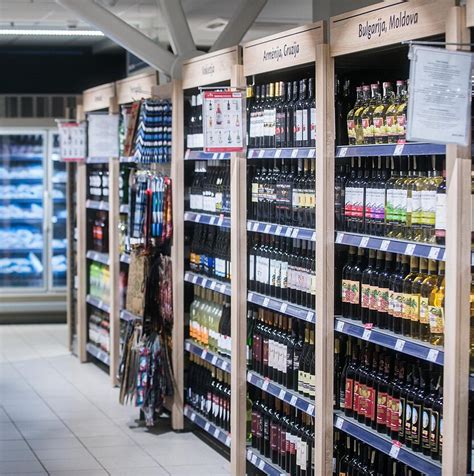 Alkoholio butelių virtinė ir šeimos siluetai