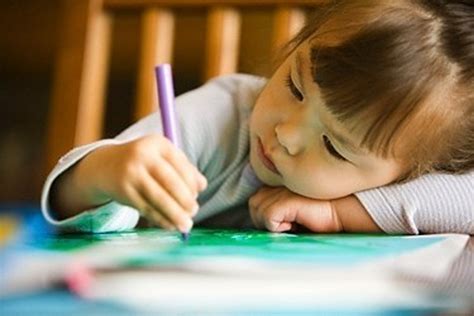 vaikas piešia ir naudojasi žirklėmis