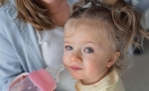 Vaikas geria pieną iš buteliuko