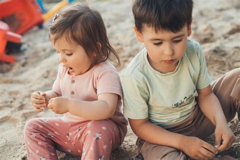 Kūdikis žaidžia su smėliu lauke