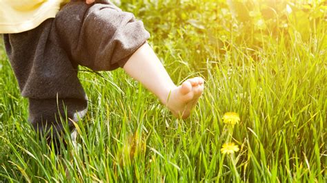 Vaiko pėda vaikštanti basomis po skirtingus paviršius