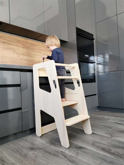 Montessori virtuvės bokštelis su vaikų piešiniais