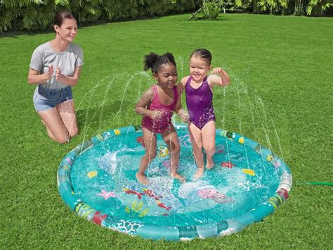 Vaikų rankos piešia ant vandens kilimėlio su įvairiais priedais