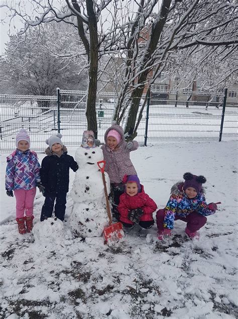 Vaikai lipdo sniego senį lauke