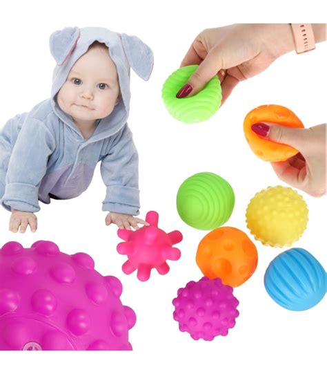 Vaiko rankose laikomas barškutis su skirtingomis tekstūromis