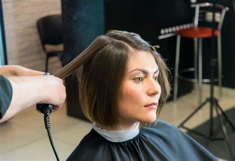 Moteris kirpykloje kerpa plaukus