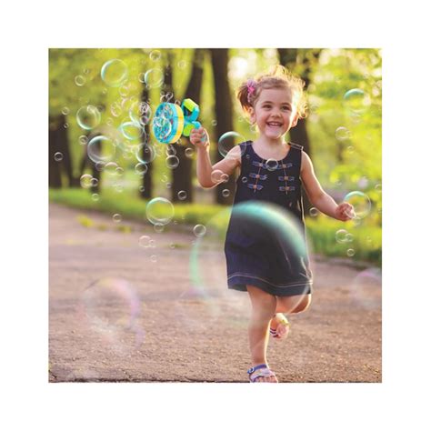 Kūdikis žaidžia su muilo burbulais lauke