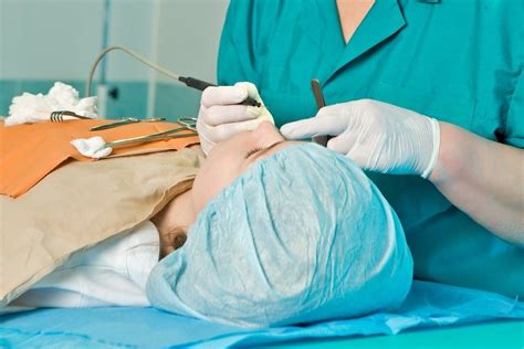 Pacientas po ausų plastinės operacijos su tvarščiais