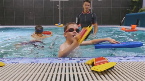 Vaikai baseine su treneriu