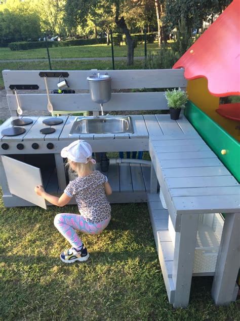 Tėvai ir du vaikai žaidžia kartu lauke