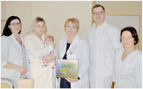 Nuotrauka, vaizduojanti gydytojų komandą, dirbančią su naujagimiu