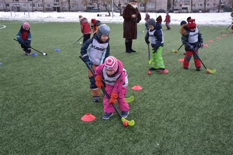 vaikas žaidžia žolės riedulį su apsauginiais įrenginiais