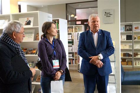 Nuotrauka, vaizduojanti senjorus, besidominčius knygomis bibliotekoje.